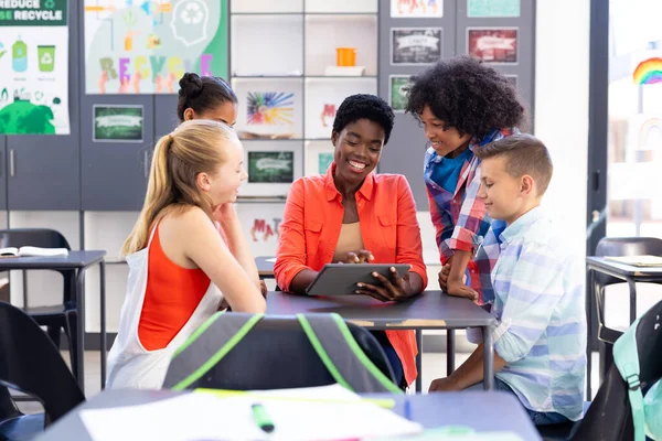 Smiling Diverse Female Teacher Pupils Looking Tablet Together Classroom Education — Stock Photo, Image