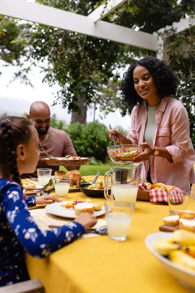 幸せな出産の両親と娘は食べ物を提供し 庭で食事をするためにテーブルに座って スペースをコピーします 一緒に 食べ物とライフスタイル 変わらない — ストック写真