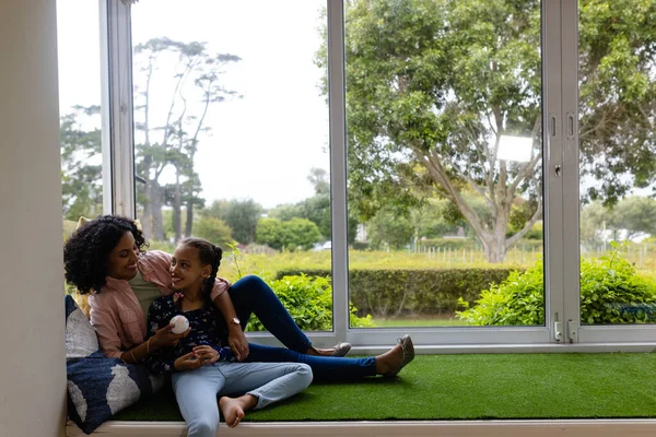 快乐的小鸟妈妈和女儿坐在窗边阳光灿烂的花园里 在家里聊天 复制空间 生活方式和家庭生活 — 图库照片