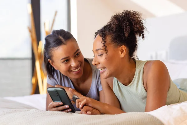 快乐的一对同性恋夫妇在床上用智能手机在卧室里 生活方式 沟通和家庭生活 — 图库照片
