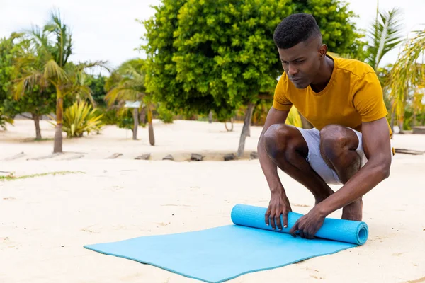 Biracial Man Rolling Mat Practising Yoga Sunny Beach Unaltered Healthy — Stock Photo, Image