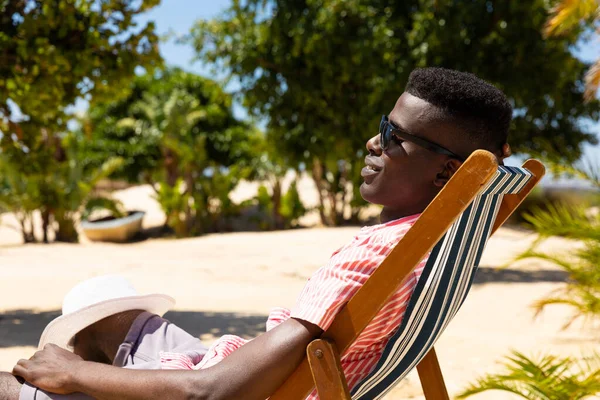 Smiling Biracial Man Sunglasses Sitting Deckchair Sunny Beach Copy Space — Stock Photo, Image