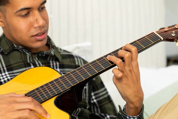 Feliz Hombre Biracial Sentado Cama Tocando Guitarra Casa Música Estilo —  Fotos de Stock