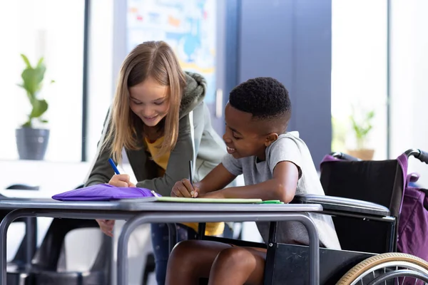 Happy Diverse Schoolgirl Schoolboy Wheelchair Writing Together Desk Class Education — Stock Photo, Image