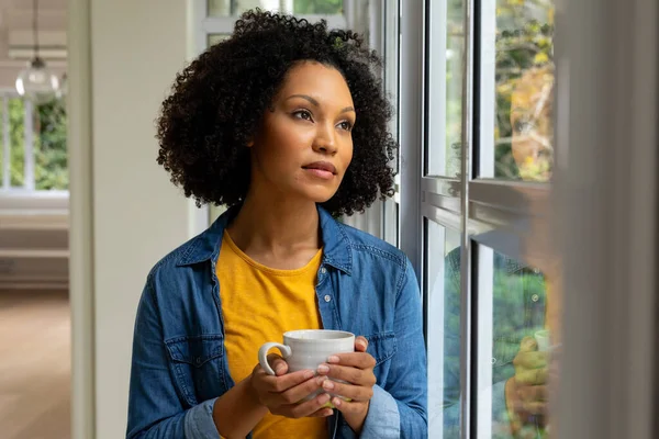 Melez Bir Kadın Elinde Kahve Bardağıyla Pencereden Dışarı Bakıyor Rahatlama — Stok fotoğraf