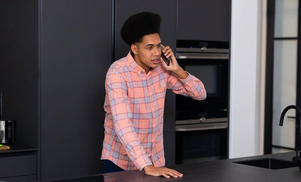 Счастливого Расового Человека Опирающегося Столешницу Разговаривающего Смартфону Современной Кухне Коммуникация — стоковое фото