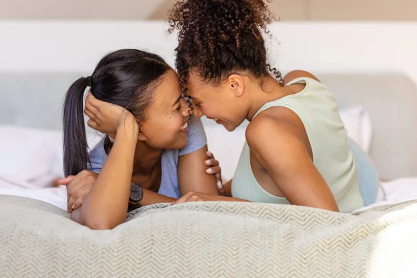Feliz Pareja Lesbianas Birraciales Abrazando Hablando Cama Dormitorio Relajación Estilo —  Fotos de Stock