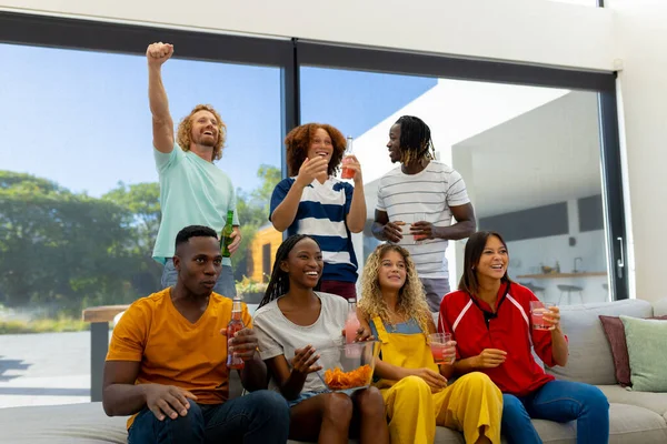 一群多样化的朋友坐在沙发上 看电视上的运动 生活方式 闲暇时间 夏天和阳光 — 图库照片