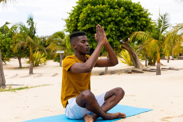 Skupiony Dwurasowy Mężczyzna Praktykujący Jogę Siedzący Macie Medytujący Słonecznej Plaży — Zdjęcie stockowe