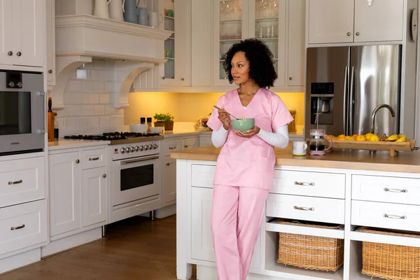 Happy Biracial Female Medical Worker Scrubs Eating Bowl Cereal Kitchen — Stock Photo, Image