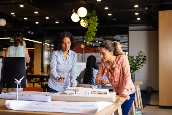 Diverse Kvinnelige Arkitekter Som Diskuterer Ved Hjelp Modell Arbeidstegninger Tilfeldig – stockfoto