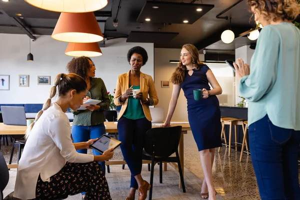 オフィスでのカジュアルな会議でタブレットを使用して議論の多様な女性同僚 カジュアルオフィス チームワーク ビジネス コミュニケーション 変更なし — ストック写真