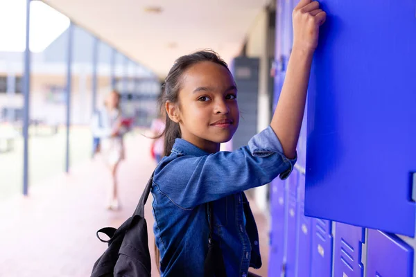 学校の廊下のロッカーの隣に立っている幸せな女子高生の肖像画 学習コンセプト — ストック写真