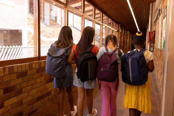 不同的女学生穿着书包走在学校走廊上 学习和教育 — 图库照片