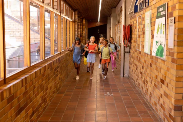 Diverse Happy Schoolgirls Bags Running Embracing Elementary School Corridor School — Stock Photo, Image