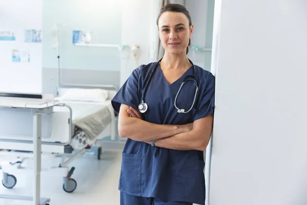 病院で青いスクラブとステスコープを着用した幸せな白人女性医師の肖像画 変わらない — ストック写真