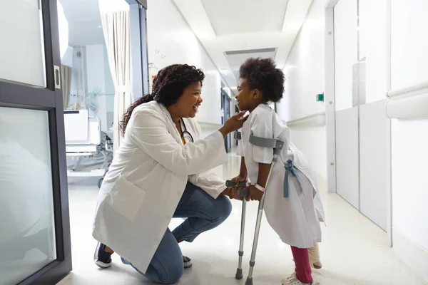 Hastanenin Koridorunda Koltuk Değnekleriyle Yürüyen Afrika Kökenli Amerikalı Kadın Doktor — Stok fotoğraf