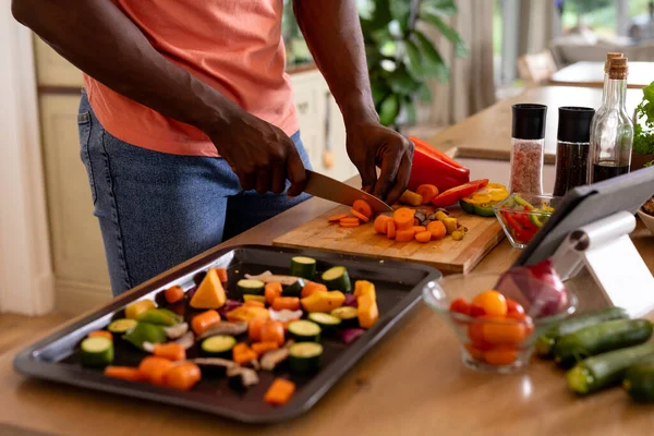 Sección Media Del Hombre Afroamericano Picando Verduras Usando Tableta Cocina — Foto de Stock