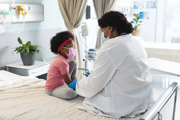 非洲裔美国女医生戴着口罩在医院为女病人接种疫苗 医药和保健 未经改动 — 图库照片