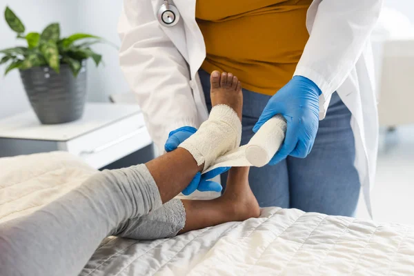 Midsection Africké Americké Lékařky Oblékání Dívka Nohy Pacienta Obvazem Nemocnici — Stock fotografie