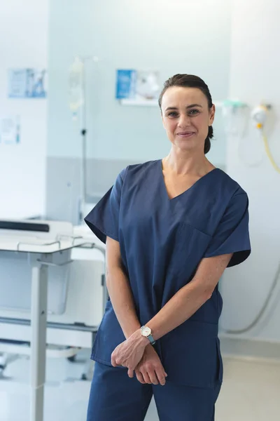 病院で青いスクラブを着用した幸せな白人女性医師の肖像画 変わらない — ストック写真