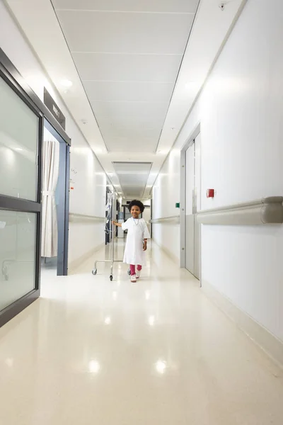快乐的非洲裔美国女孩患者抱着点滴走在医院的走廊上 医药和保健 — 图库照片