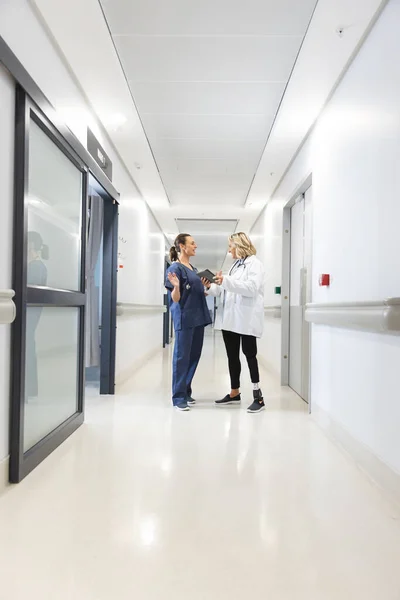 快乐的高加索女医生与听诊器使用石碑在走廊在医院 协同工作 医疗和保健 未加改动 — 图库照片