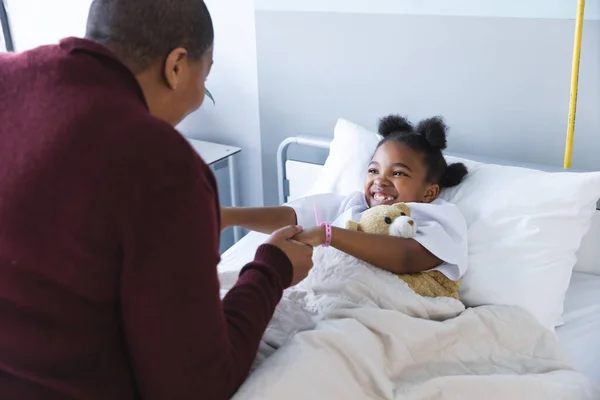 アフリカ系アメリカ人少女患者がベッドに横たわり 病院の患者室で母親と手を握った 医学および医療 変わらない — ストック写真