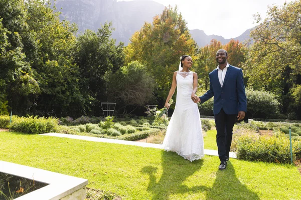 Glückliche Afrikanisch Amerikanische Brautpaar Händchen Haltend Und Fuß Sonnigen Garten — Stockfoto