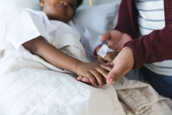 アフリカ系アメリカ人少女患者がベッドに横たわり 病院の患者室で母親と手を握った 医学および医療 変わらない — ストック写真