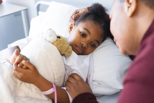 アフリカ系アメリカ人の少女患者が病院の患者室で母親とベッドに横たわっている 医学および医療 変わらない — ストック写真