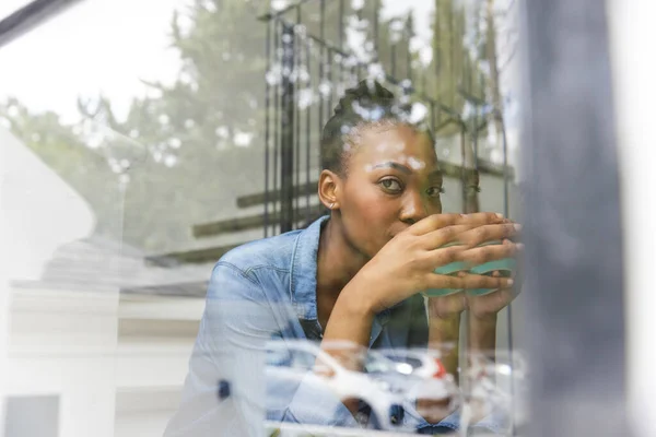 Задумчивая Американка Африки Сидит Лестнице Пьет Кофе Смотрит Окно Свободное — стоковое фото