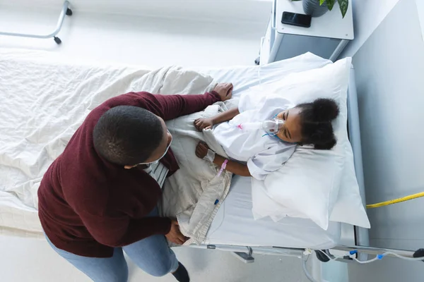 アフリカ系アメリカ人の少女患者は 病院で母親と共に酸素マスクでベッドに横たわっている 医学および医療 変わらない — ストック写真