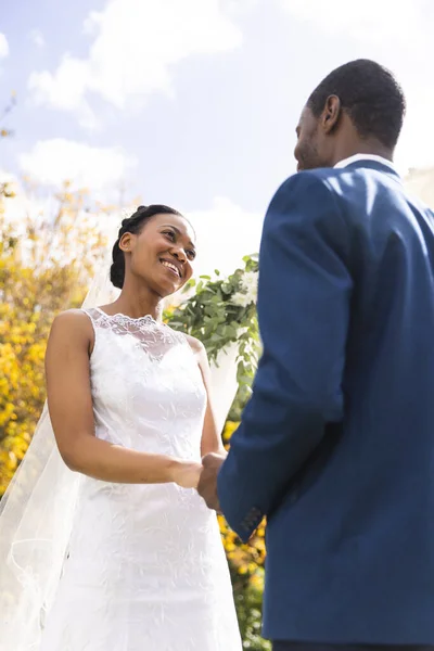 在阳光灿烂的花园里 快乐的非洲裔美国新娘和新郎牵着手举行婚礼 仪式和生活方式 — 图库照片