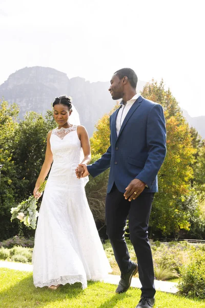Gelukkige Afrikaanse Amerikaanse Bruid Bruidegom Hand Hand Wandelen Zonnige Tuin — Stockfoto