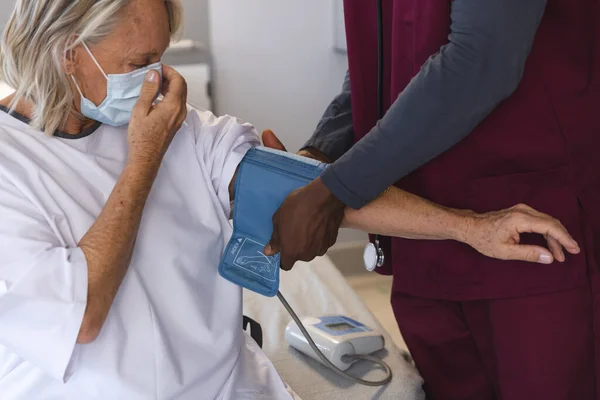 Afrykański Lekarz Mierzący Ciśnienie Krwi Starszego Białego Pacjenta Noszącego Maski — Zdjęcie stockowe