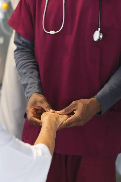Parte Central Médico Afro Americano Examinando Mãos Uma Paciente Caucasiana — Fotografia de Stock