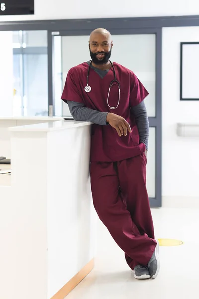 一位快乐的非洲裔美国男医生在医院接待处穿着洗涤剂的画像 医疗和保健 未加改动 — 图库照片