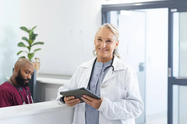Retrato Feliz Médico Feminino Caucasiano Sênior Segurando Tablet Recepção Hospital — Fotografia de Stock