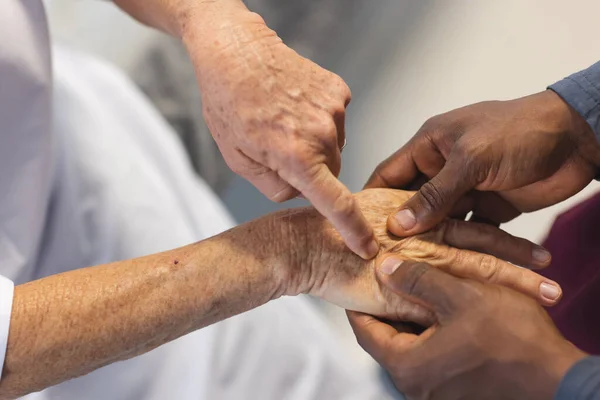 Середина Африканского Американского Врача Мужчины Осматривает Руки Пожилой Кавказской Пациентки — стоковое фото