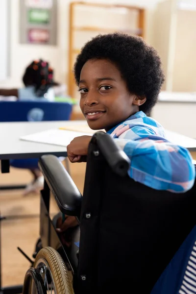 Portret Szczęśliwego Dwurasowego Chłopca Wózku Inwalidzkim Uśmiechającego Się Szkole Podstawowej — Zdjęcie stockowe