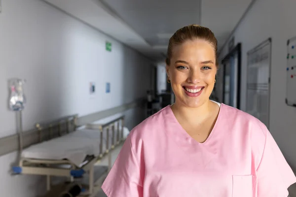 病院の廊下でスクラブを着た幸せな白人女性医師の肖像画 コピースペース 医療および仕事 変わらない — ストック写真