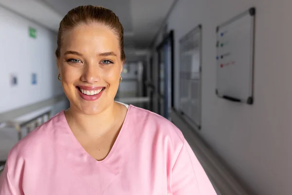 病院の廊下でスクラブを着た幸せな白人女性医師の肖像画 コピースペース 医療および仕事 変わらない — ストック写真
