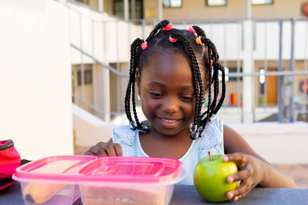 테이블에 아프리카계 미국인 여학생과 건강한 초등학교 밖에서 사과를 변하지 — 스톡 사진