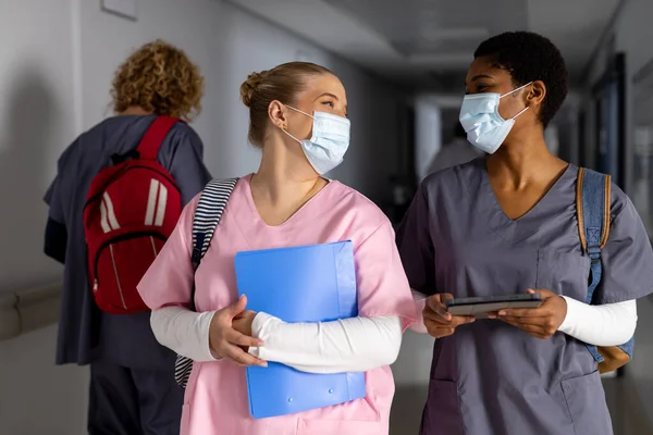 Çeşitli Kadın Doktorlar Yüz Maskeleri Takarak Hakkında Konuşuyor Hastanenin Koridorunda — Stok fotoğraf