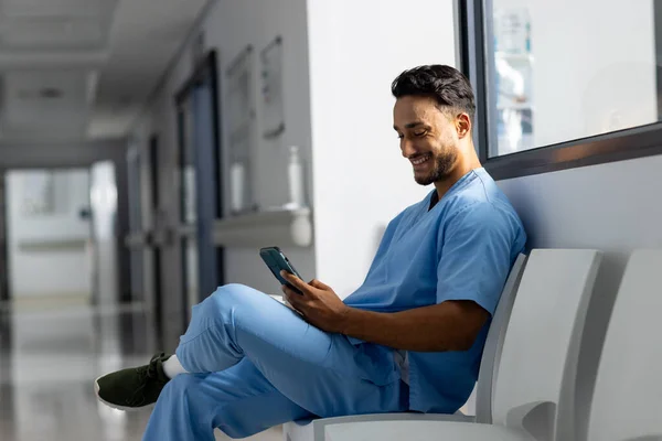 Médico Biracial Masculino Usando Matorrales Usando Smartphone Corredor Hospital Hospital —  Fotos de Stock