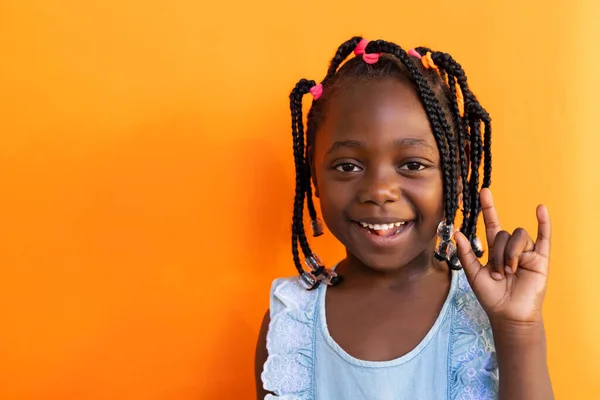아프리카계 미국인 여학생은 초등학교에서 오렌지색 배경에 제스처를하고 있습니다 변함없는 — 스톡 사진