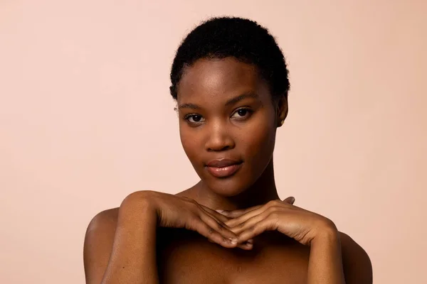 African american woman with short hair with hands under chin. Femininity, face, facial expressions, body, skin, makeup, fashion and beauty, unaltered.