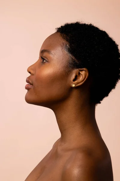 Profile of african american woman with short hair looking up. Femininity, face, facial expressions, body, skin, makeup, fashion and beauty, unaltered.
