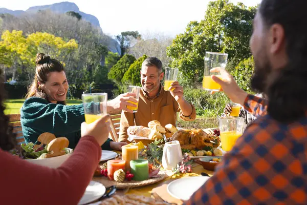 在阳光明媚的花园里 快乐而多样的男女朋友在感恩节庆祝宴会上祝酒 爱国主义 美国文化和传统 — 图库照片